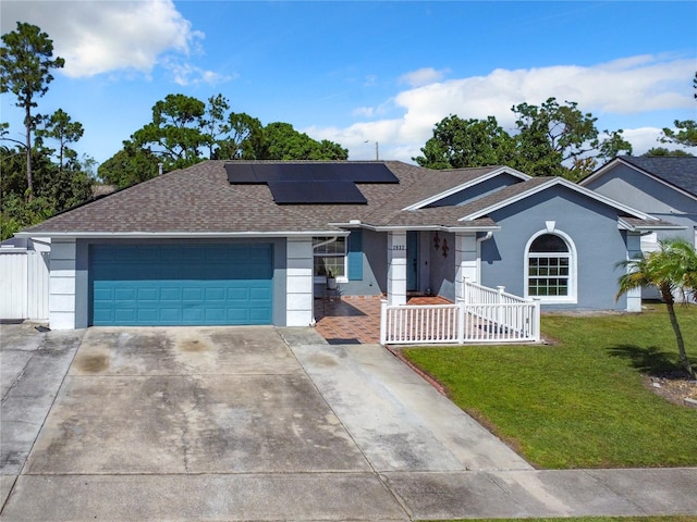 single story home featuring a garage, a front lawn, and solar panels