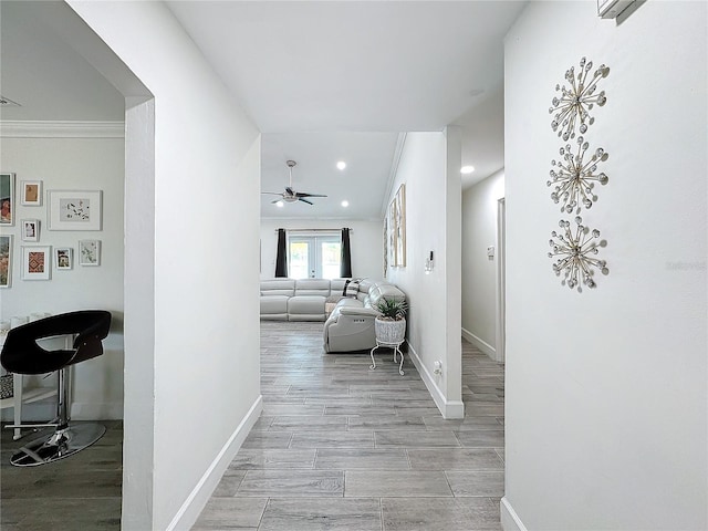 hallway featuring french doors, light hardwood / wood-style floors, and crown molding