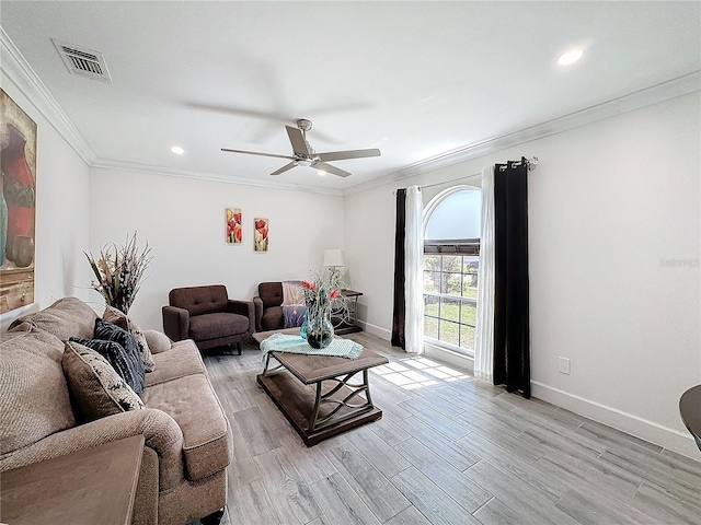 living room with ornamental molding, light wood-type flooring, and ceiling fan