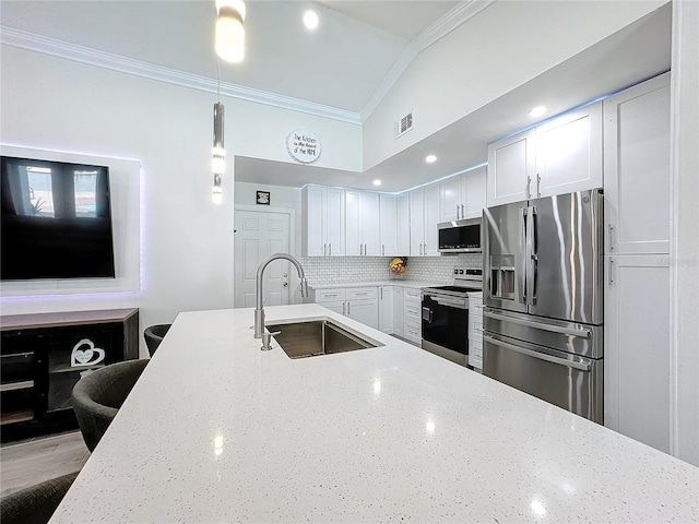 kitchen featuring appliances with stainless steel finishes, white cabinetry, sink, and decorative light fixtures