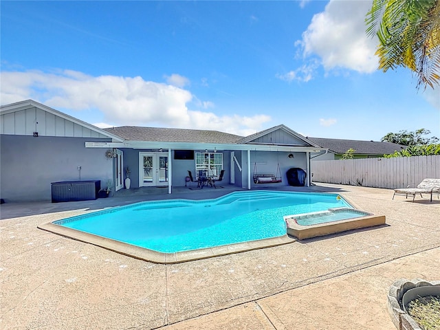 view of swimming pool with french doors, a patio area, and an in ground hot tub