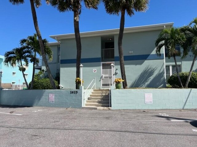 view of front facade with a fenced front yard, a gate, and stucco siding