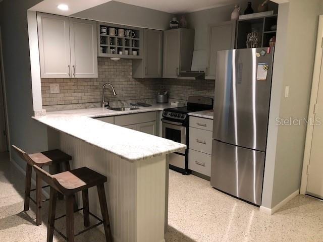 kitchen with gray cabinets, sink, a kitchen breakfast bar, kitchen peninsula, and stainless steel appliances