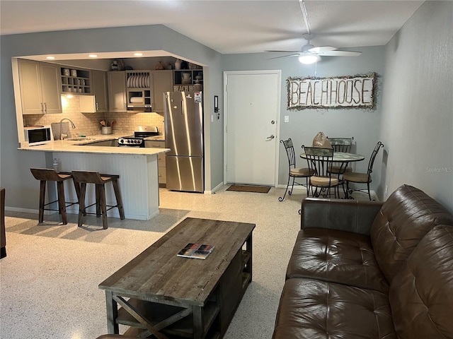 living area with light speckled floor, recessed lighting, ceiling fan, and baseboards