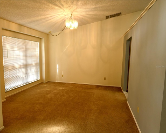 unfurnished room with a notable chandelier, carpet floors, and a textured ceiling