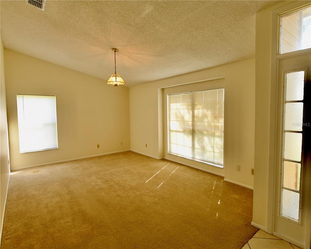 carpeted empty room featuring a textured ceiling