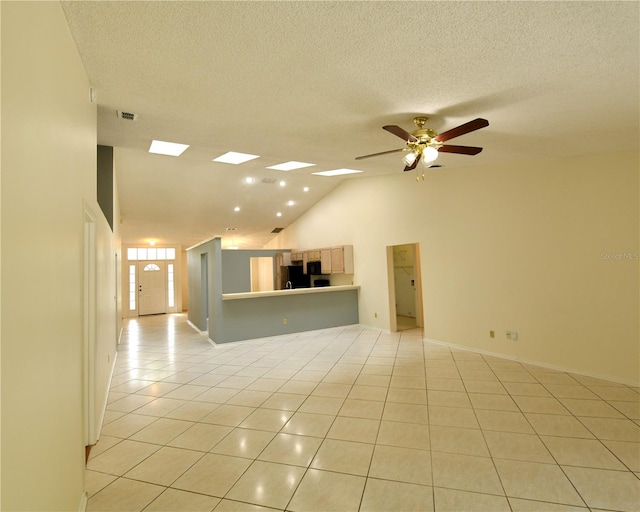 unfurnished living room featuring lofted ceiling, light tile patterned flooring, a textured ceiling, and ceiling fan