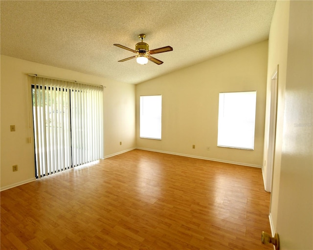 empty room featuring lofted ceiling, light hardwood / wood-style flooring, a textured ceiling, and ceiling fan