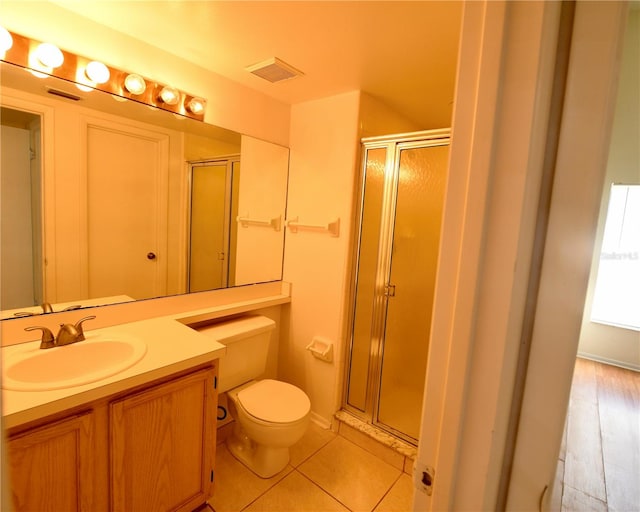 bathroom featuring vanity, toilet, hardwood / wood-style flooring, and a shower with shower door