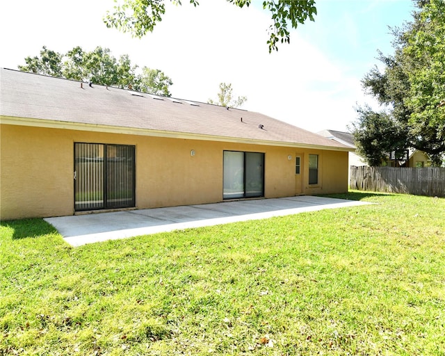 rear view of property with a yard and a patio area