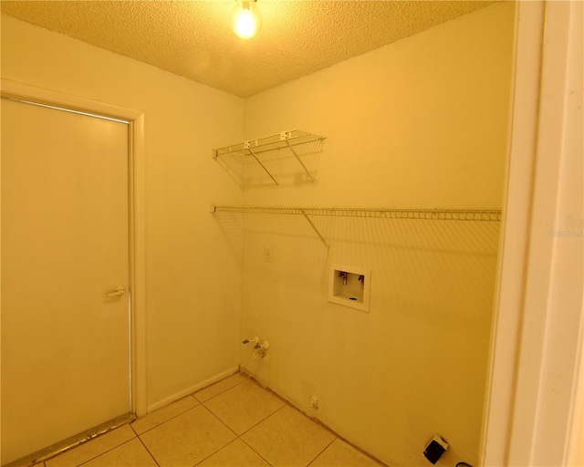 clothes washing area with hookup for a washing machine, a textured ceiling, tile patterned flooring, and hookup for a gas dryer