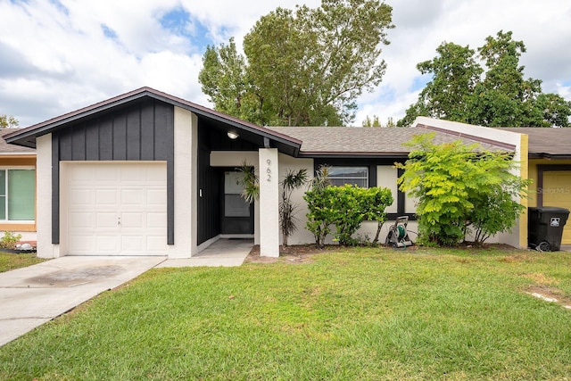 mid-century modern home featuring an attached garage, driveway, a shingled roof, and a front yard