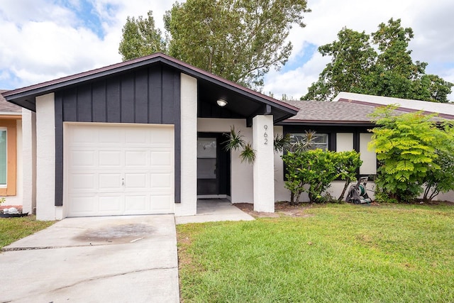 view of front facade featuring roof with shingles, stucco siding, a front yard, a garage, and driveway