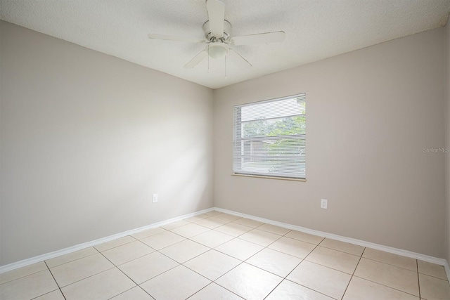 tiled spare room featuring a textured ceiling and ceiling fan