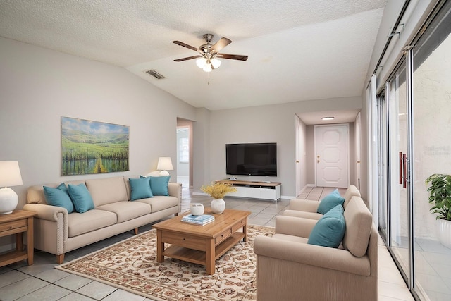 tiled living room featuring lofted ceiling, ceiling fan, and a textured ceiling