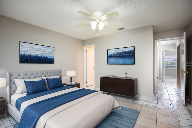 tiled bedroom with ceiling fan and a textured ceiling