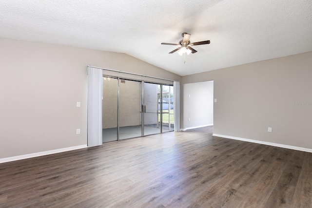 unfurnished bedroom with a textured ceiling, dark wood-type flooring, baseboards, vaulted ceiling, and access to exterior