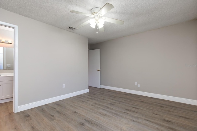 unfurnished bedroom with light wood-style floors, visible vents, a textured ceiling, and baseboards