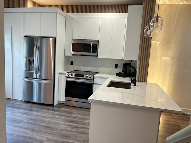 kitchen featuring hardwood / wood-style floors, sink, appliances with stainless steel finishes, and white cabinetry