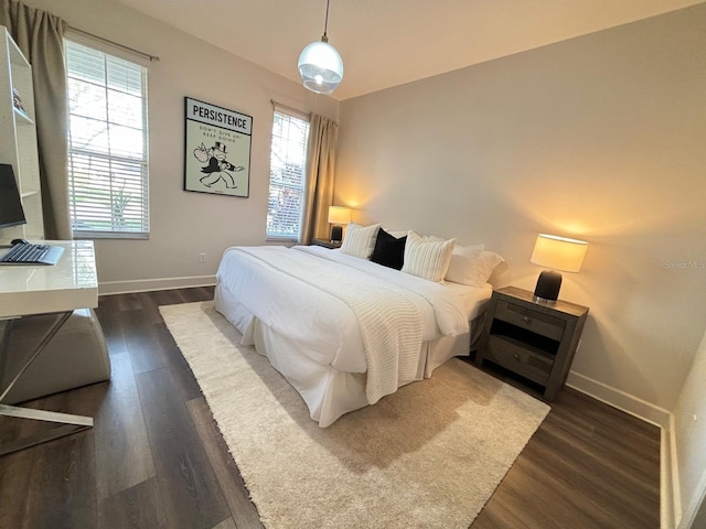 bedroom featuring multiple windows and dark hardwood / wood-style floors