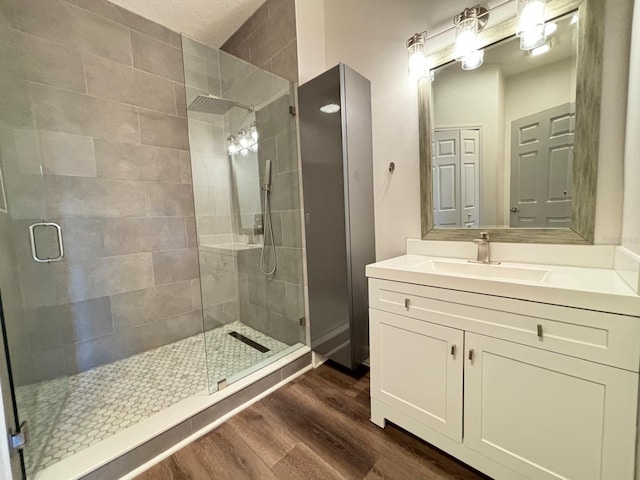 bathroom with vanity, hardwood / wood-style floors, and an enclosed shower