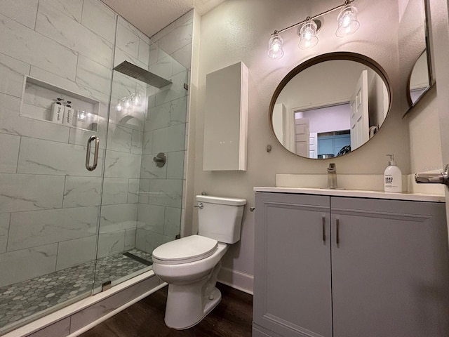 bathroom featuring toilet, an enclosed shower, vanity, and wood-type flooring