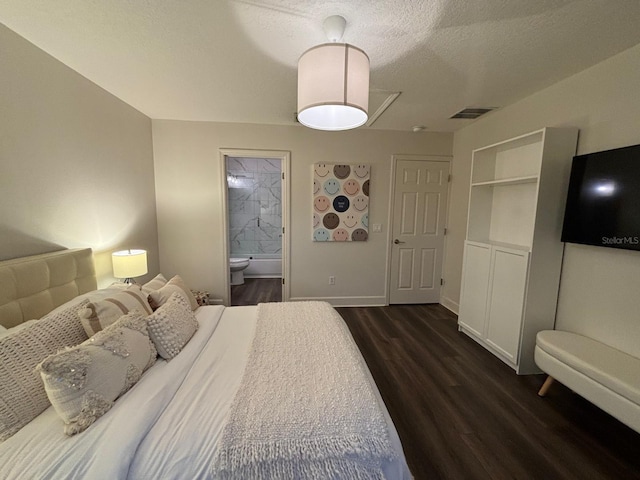 bedroom with dark wood-type flooring, connected bathroom, and a textured ceiling