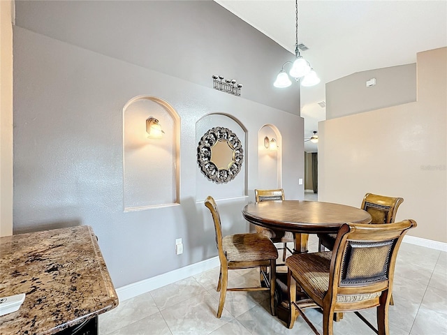 tiled dining area featuring a notable chandelier and vaulted ceiling