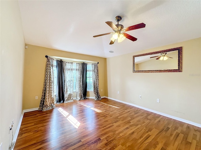 empty room with ceiling fan and wood-type flooring