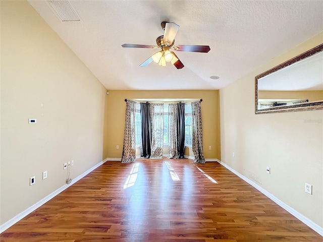 spare room featuring lofted ceiling, hardwood / wood-style floors, a textured ceiling, and ceiling fan