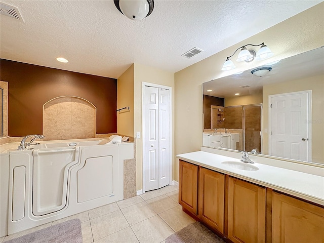 bathroom featuring vanity, a textured ceiling, independent shower and bath, and tile patterned flooring