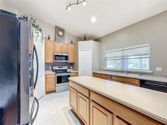 kitchen with appliances with stainless steel finishes, light brown cabinets, sink, and light tile patterned floors