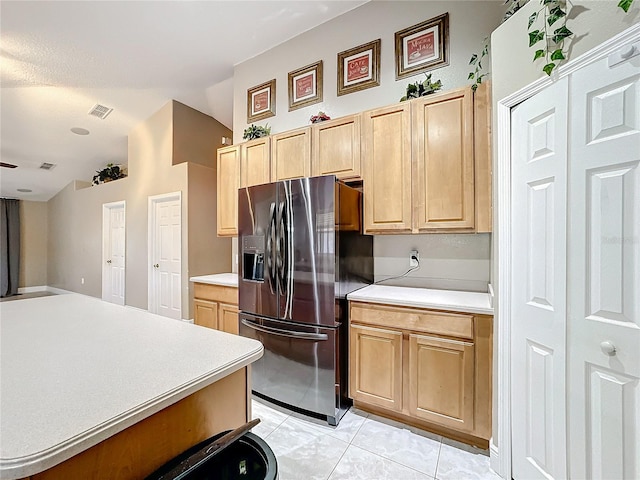 kitchen featuring light brown cabinetry, lofted ceiling, stainless steel fridge with ice dispenser, and light tile patterned floors