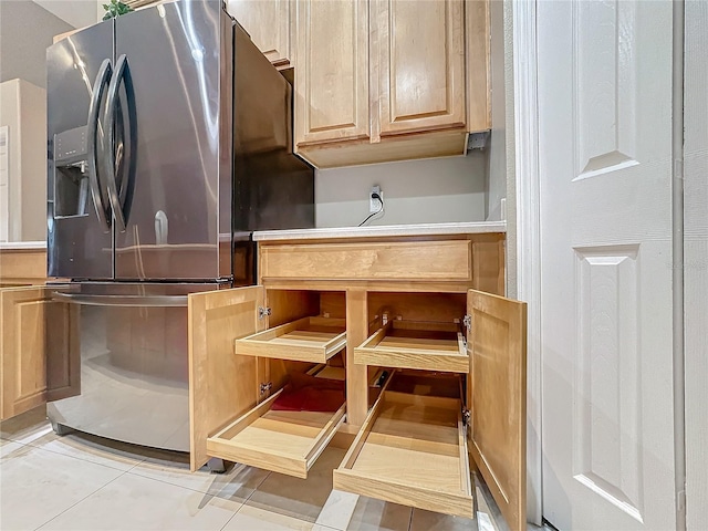 details with light brown cabinetry, light tile patterned flooring, and stainless steel refrigerator with ice dispenser