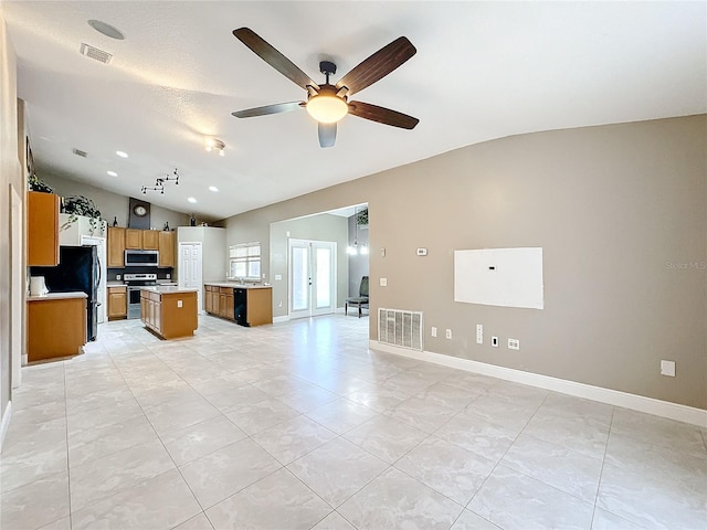 kitchen featuring lofted ceiling, ceiling fan, appliances with stainless steel finishes, light tile patterned floors, and a kitchen island