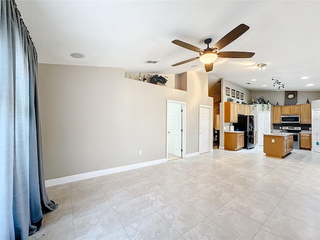 kitchen with a kitchen island, appliances with stainless steel finishes, ceiling fan, and vaulted ceiling