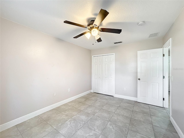 unfurnished bedroom with a closet, ceiling fan, and a textured ceiling