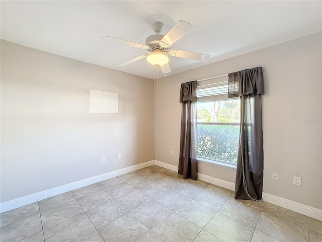 tiled empty room featuring ceiling fan