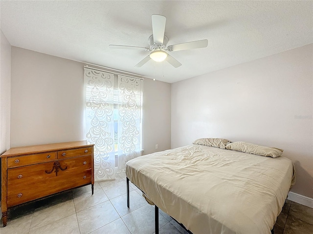 tiled bedroom with a textured ceiling and ceiling fan