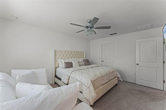 carpeted bedroom featuring a textured ceiling and ceiling fan