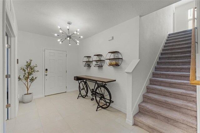 entryway featuring a textured ceiling and a chandelier