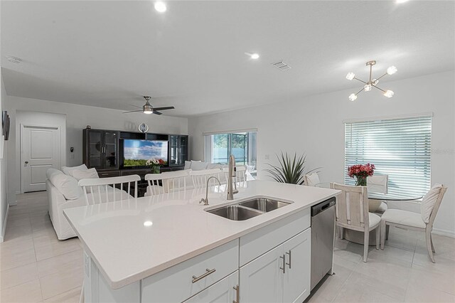 kitchen featuring white cabinets, a center island with sink, dishwasher, ceiling fan with notable chandelier, and sink