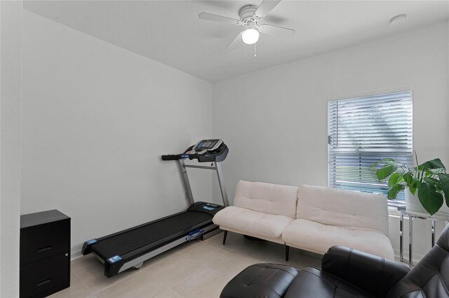 exercise room featuring ceiling fan and light tile patterned floors