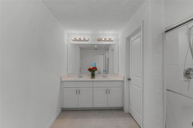 bathroom with vanity, a textured ceiling, and tile patterned floors