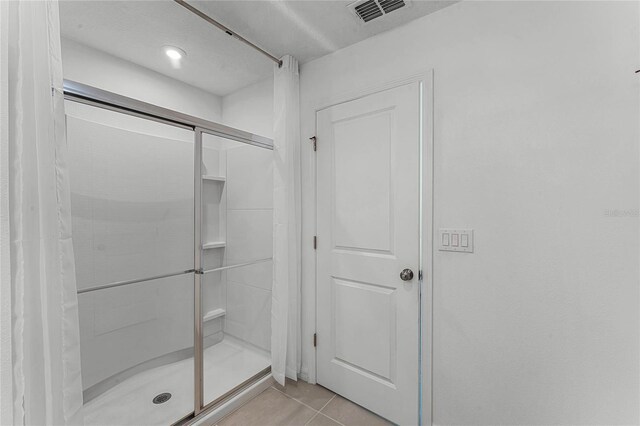 bathroom featuring tile patterned flooring and walk in shower