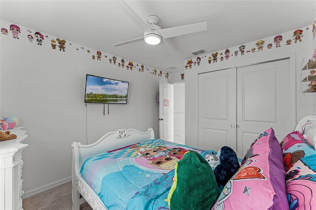 carpeted bedroom with a textured ceiling, a closet, and ceiling fan