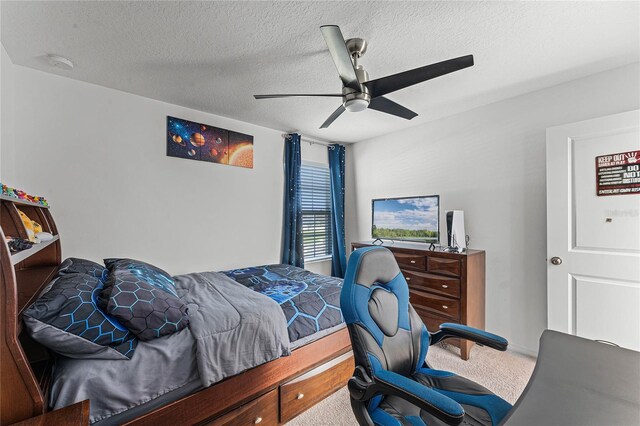 carpeted bedroom featuring a textured ceiling and ceiling fan