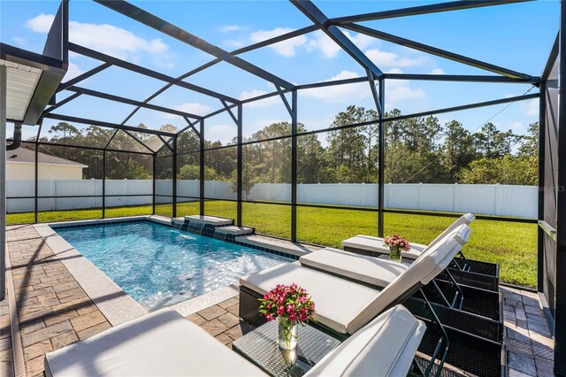 view of swimming pool with a patio, a lanai, a lawn, and pool water feature