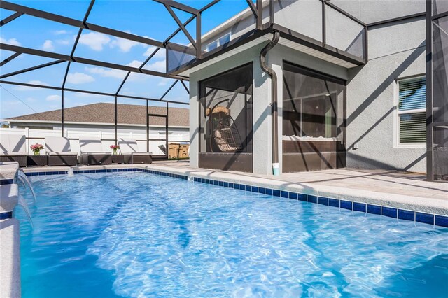 view of swimming pool with pool water feature and a lanai