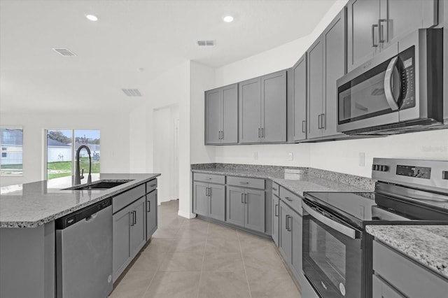 kitchen featuring visible vents, appliances with stainless steel finishes, a sink, and gray cabinetry